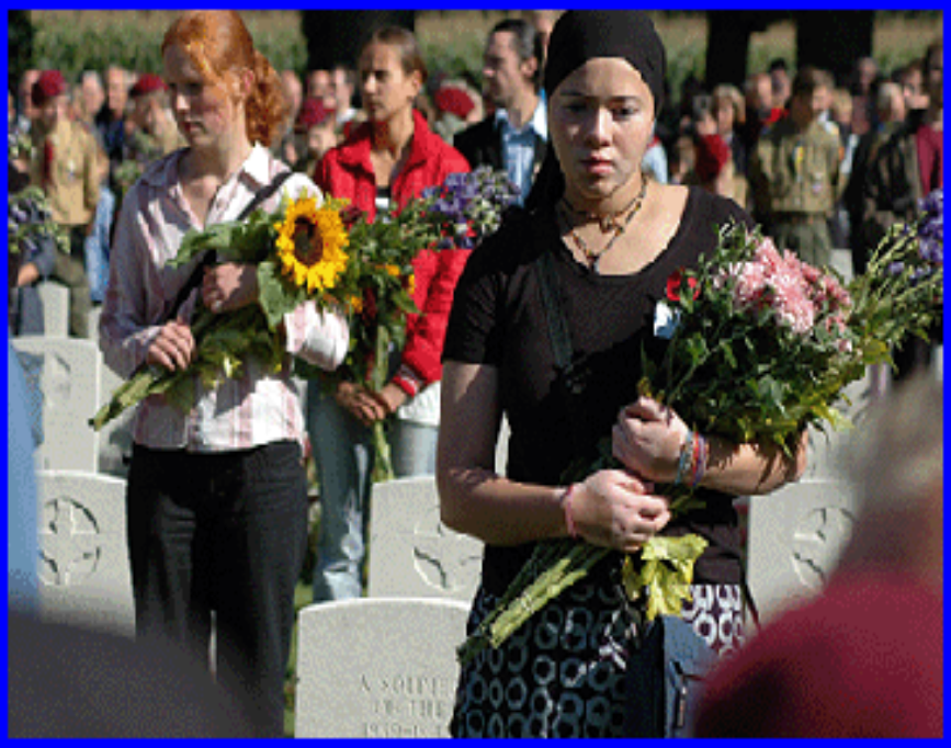 a person at a graveyard holding flowers for deceased loved one.