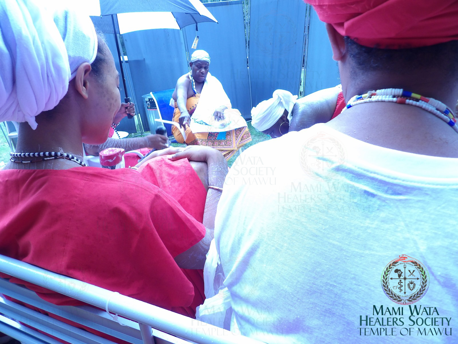 Chief Hounon Amengansie Mama Zodede directs initiate while participants observe sacred ceremony. 